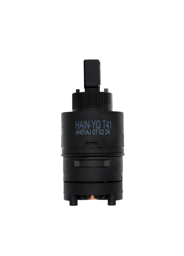 Black thermostatic cartridge with square handle connection and copper temp balance on the bottom.