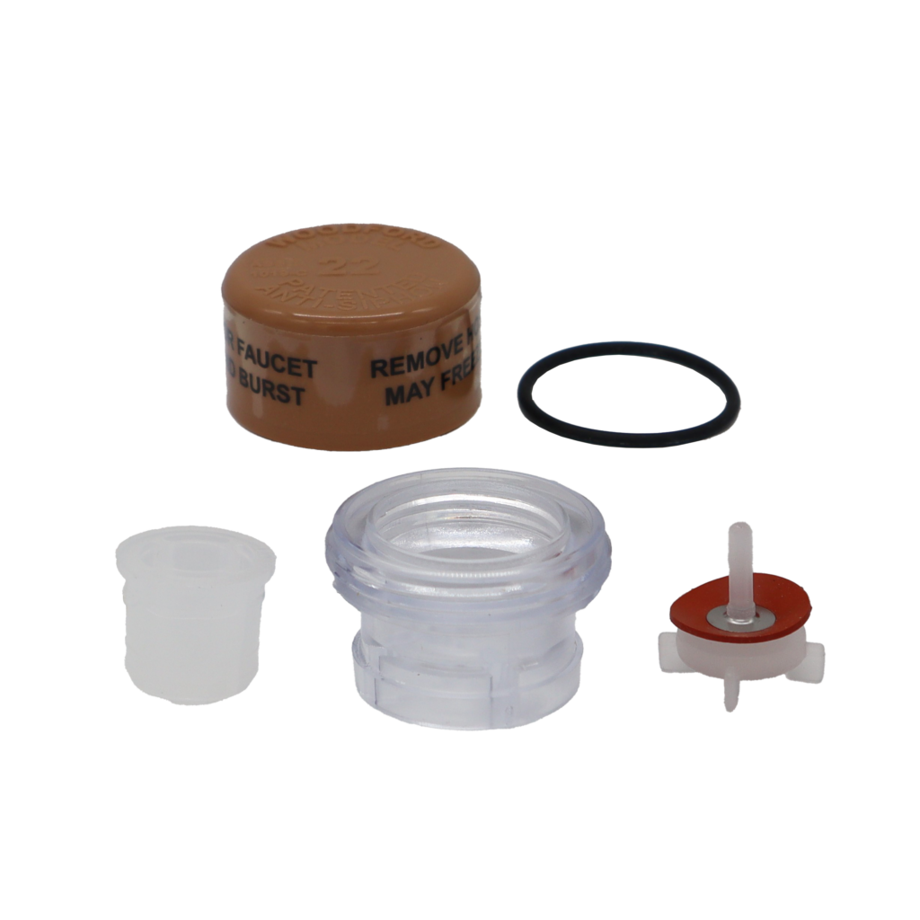 Tan plastic cap with clear plastic vacuum breaker black rubber o-ring and white plastic plunger with red rubber washer.